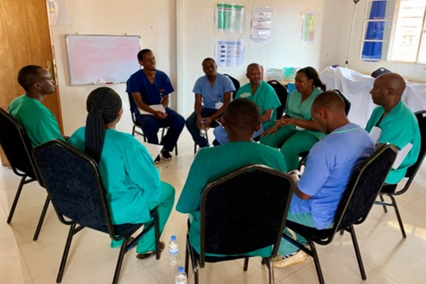 Black doctors sit in a circle during the Vital Anesthesia Simulation Training (VAST) Course