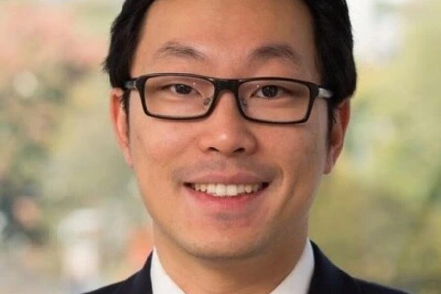 Dr. David He against the blurred background of a forest