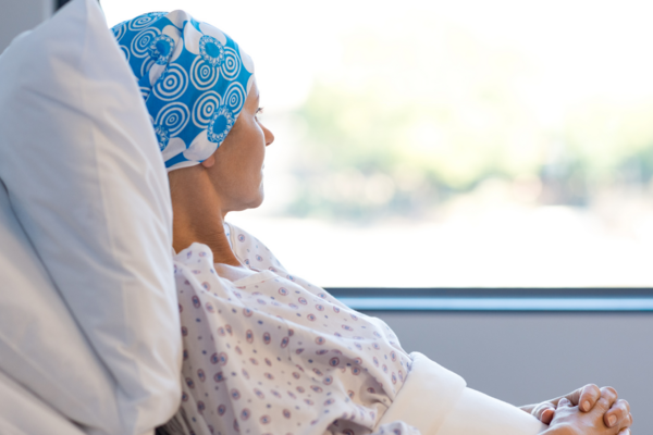 Patient lays in a hospital bed staring out of a window 