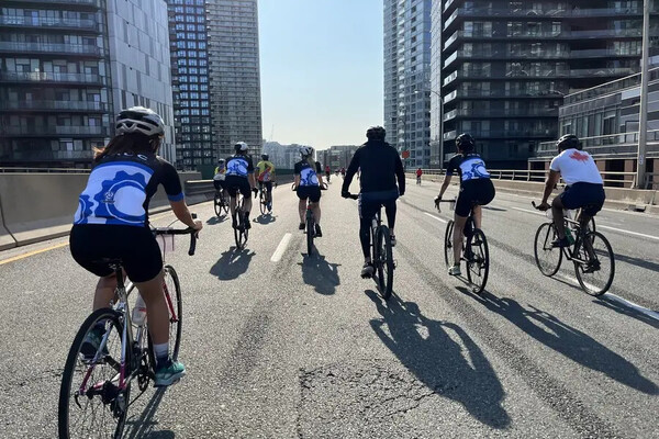 Six cyclists ride towards the skyline on the Toronto highway