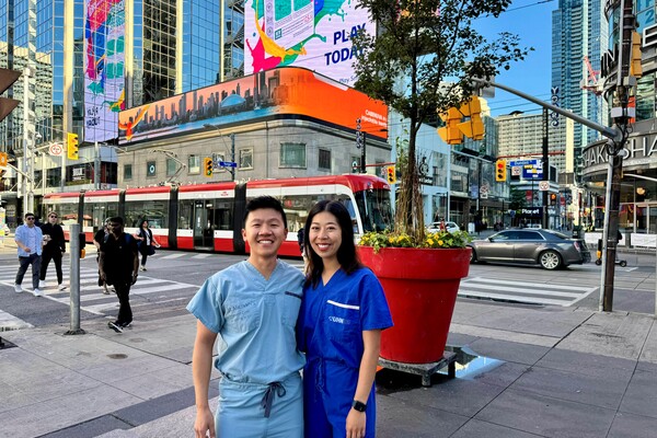 Drs Sean Leung and Jessica Nguyen posing on a busy Toronto intersection