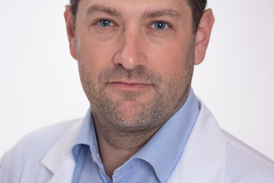 Dr. Goldenberg wears a white SickKids branded labcoat against a white background. 