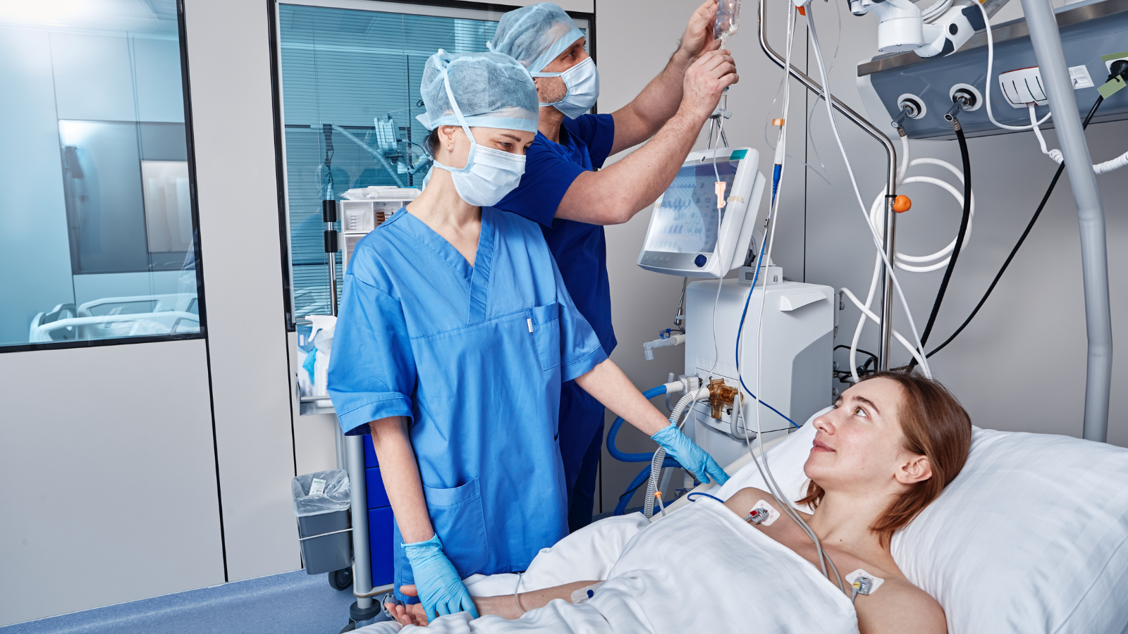 Patient in a hospital bed is comforted by a medical practitioner