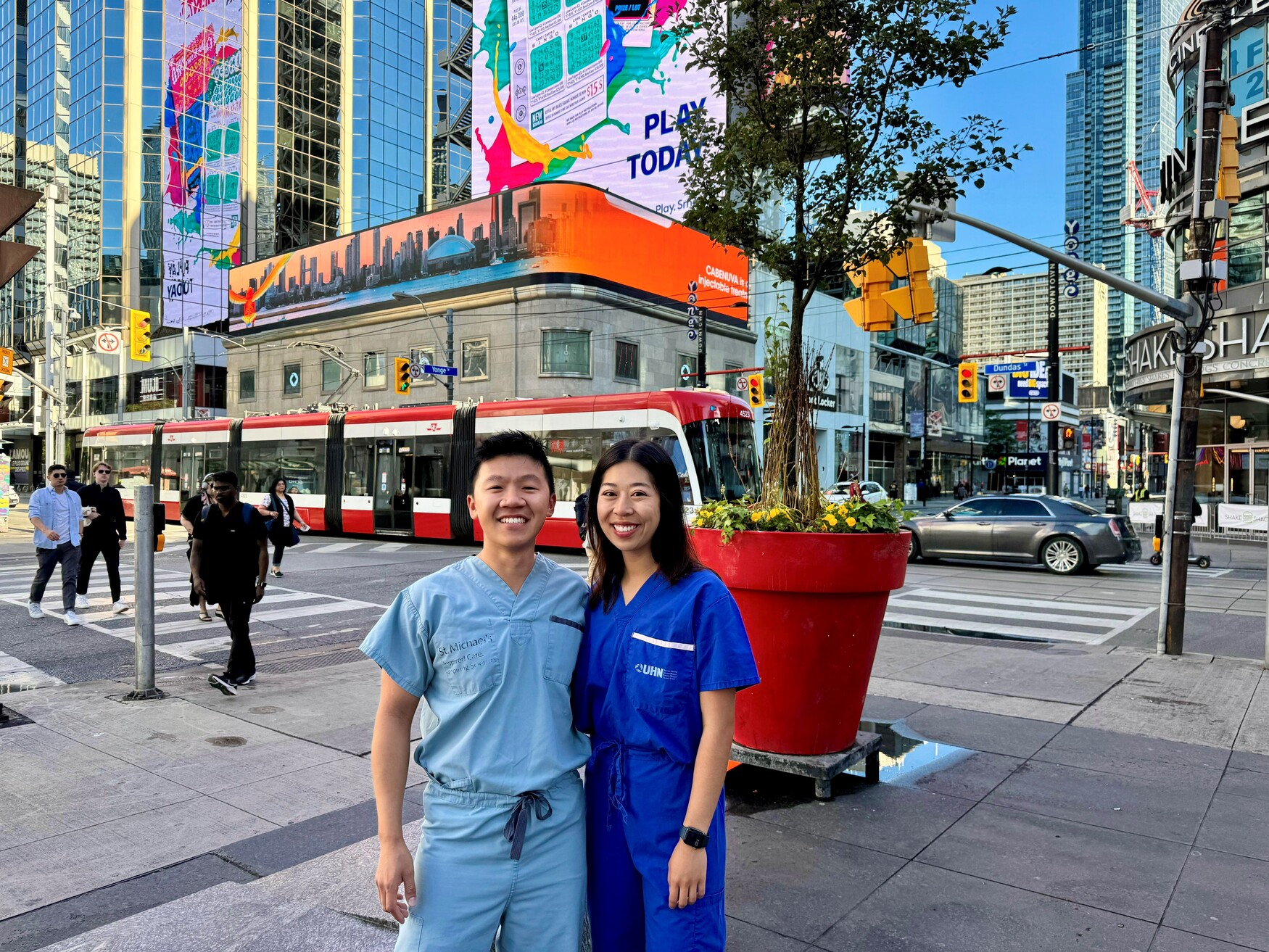 Drs Sean Leung and Jessica Nguyen posing on a busy Toronto intersection