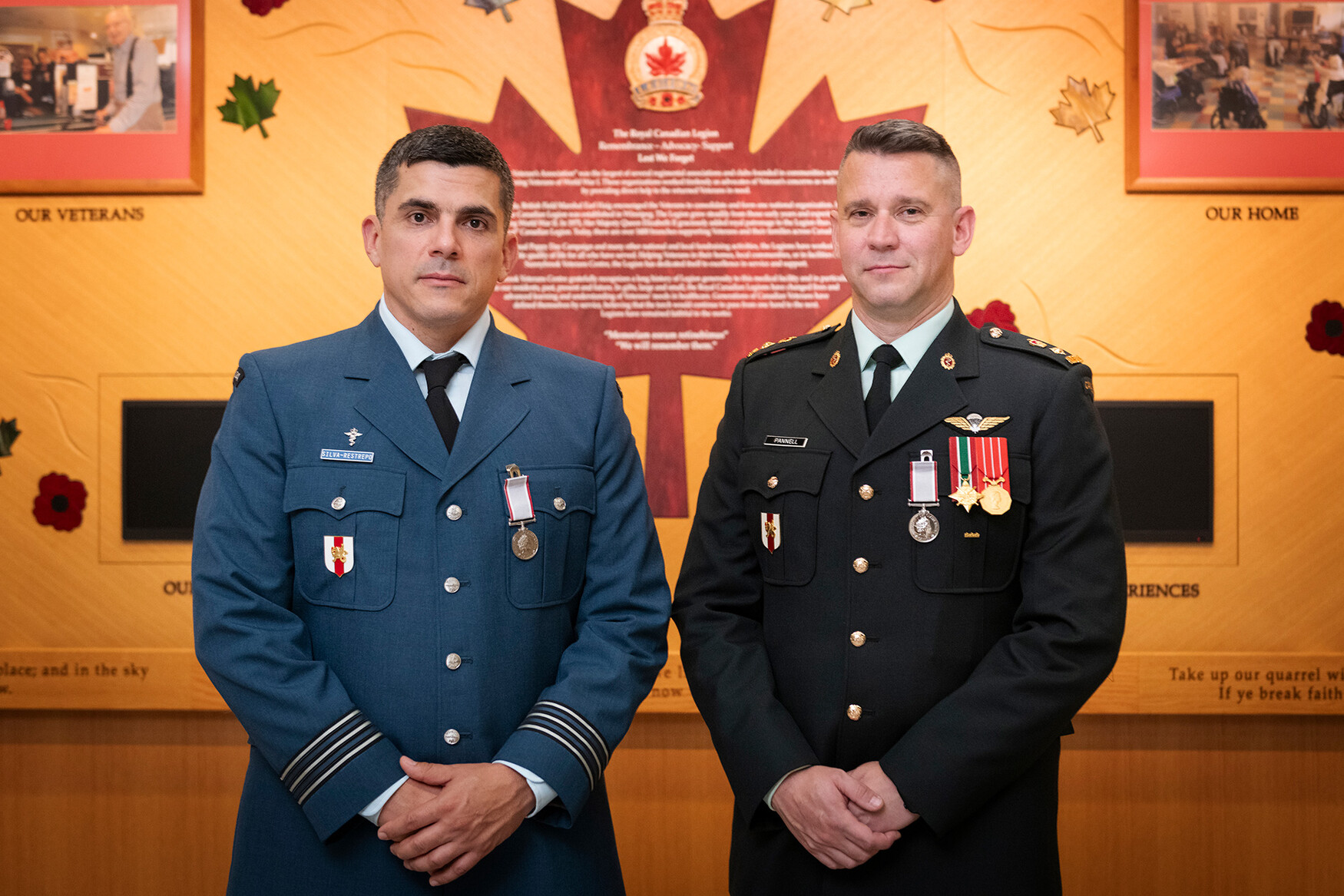 Lieutenant-Colonel Marcos Silva Restrepo and Lieutenant-Colonel Dylan Pannell in uniform against a yellow wall highlighting the Royal Canadian Legion.